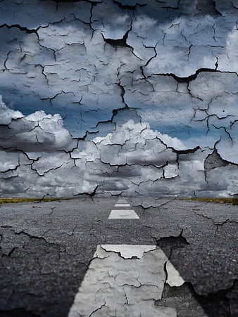 Cracked asphalt road merging into cloudy sky surreal landscape