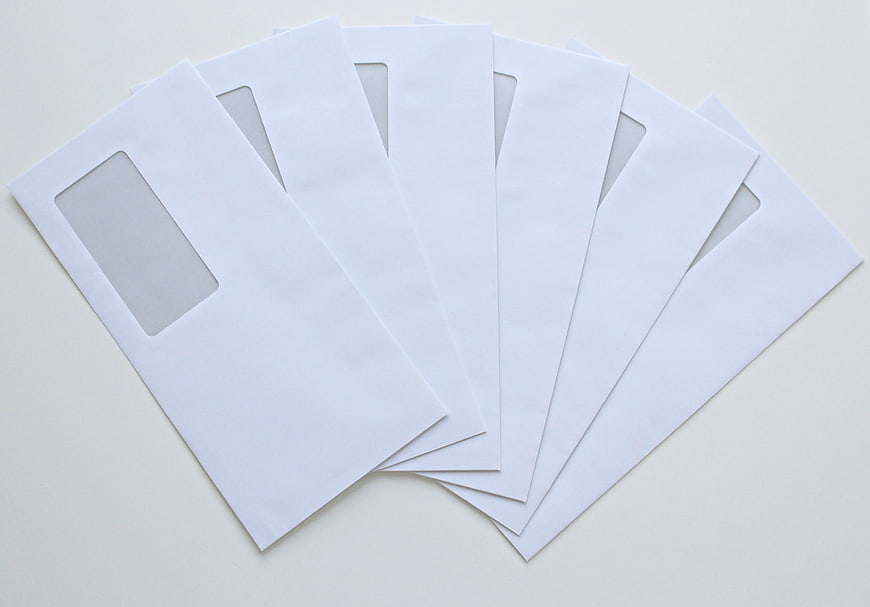 Stack of white window envelopes on white background
