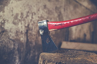 Vintage red axe embedded in a wooden log