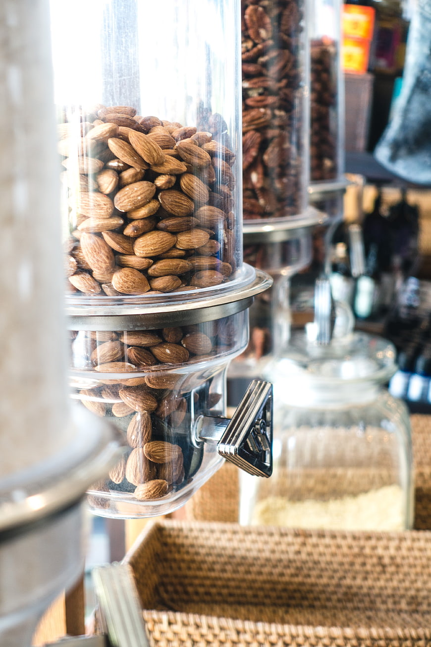 Close-up of almonds in a glass dispenser at a health food store