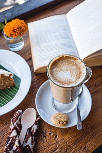Latte with cake and book on wooden table
