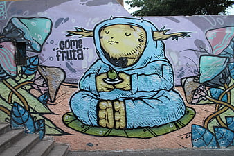 Colorful street art mural of a meditating character eating fruit