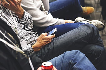Close-up of people sitting with smartphones and lanyards