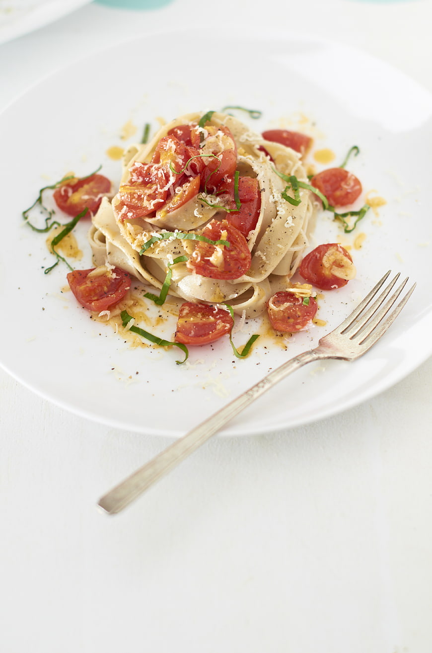 Gourmet Pasta with Tomatoes and Basil on White Plate