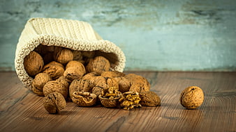 Walnuts Spilling from Knitted Bag on Wooden Table