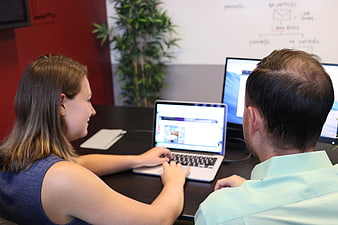 Business professionals reviewing website design on laptop in modern office