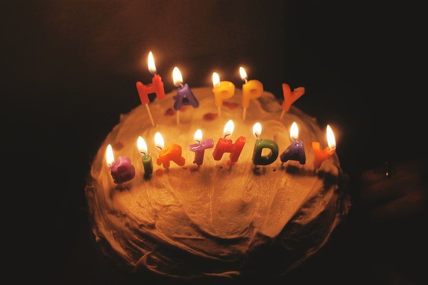 Birthday Cake with Lit Candles in Dark Room