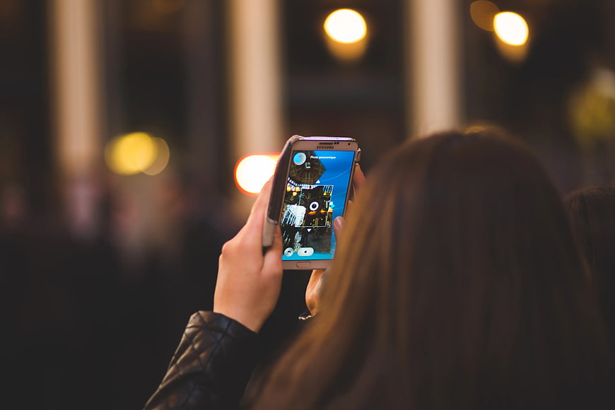 Woman Taking Night Photo with Smartphone