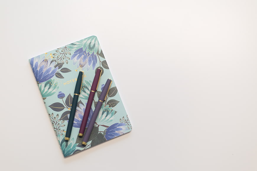 Floral Notebook with Three Pens on White Background