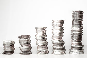 Stacks of silver coins arranged in ascending order on white background