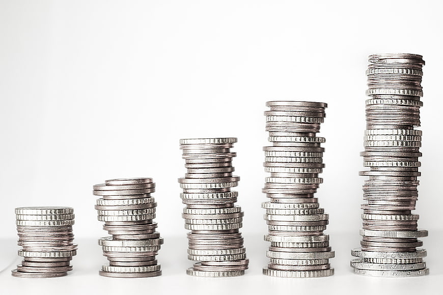 Stacks of silver coins arranged in ascending order on white background