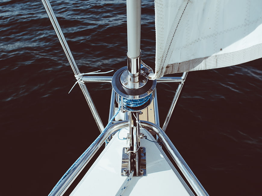 Close-up of sailboat bow and mast on dark water