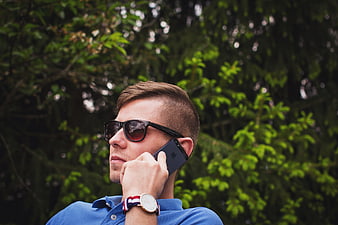 Man in sunglasses talking on smartphone outdoors
