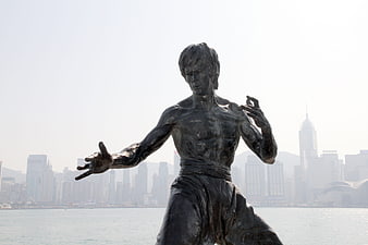 Bruce Lee Statue in Hong Kong with City Skyline Background