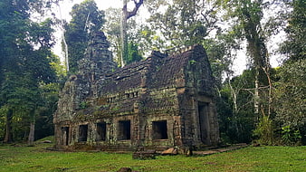 Ancient Khmer stone temple ruins nestled in lush Cambodian jungle forest