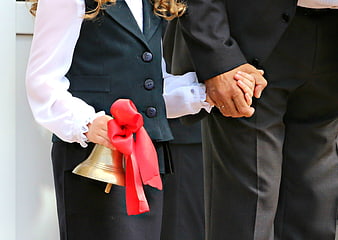 Teacher and Student Holding Hands and School Bell