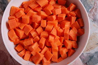 Chopped Carrots In White Bowl On Textured Tablecloth