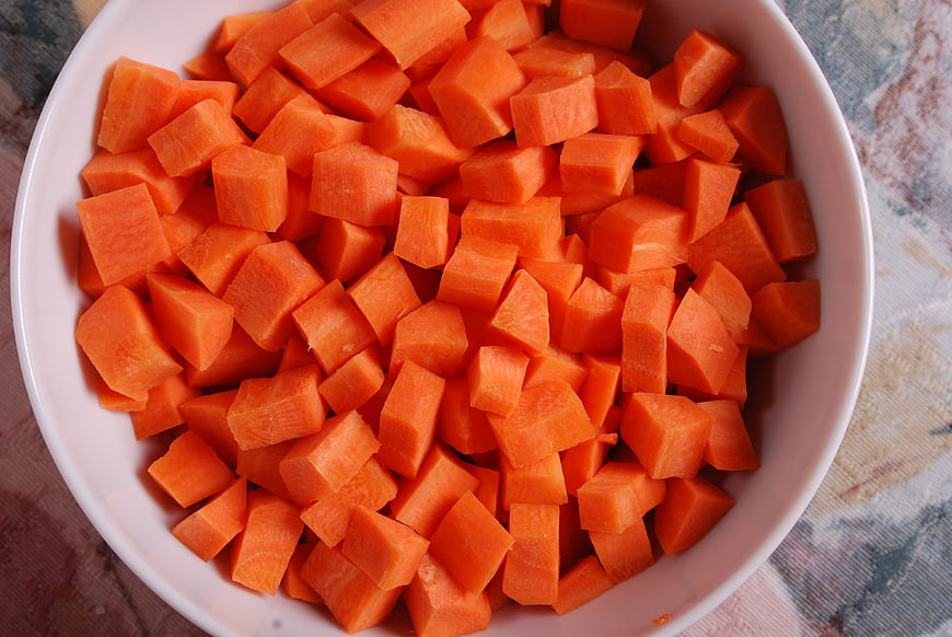 Chopped Carrots In White Bowl On Textured Tablecloth