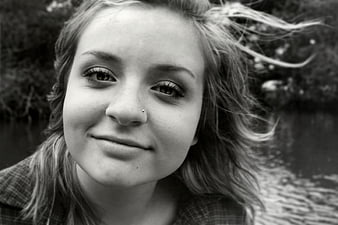 Black and white portrait of smiling young woman outdoors