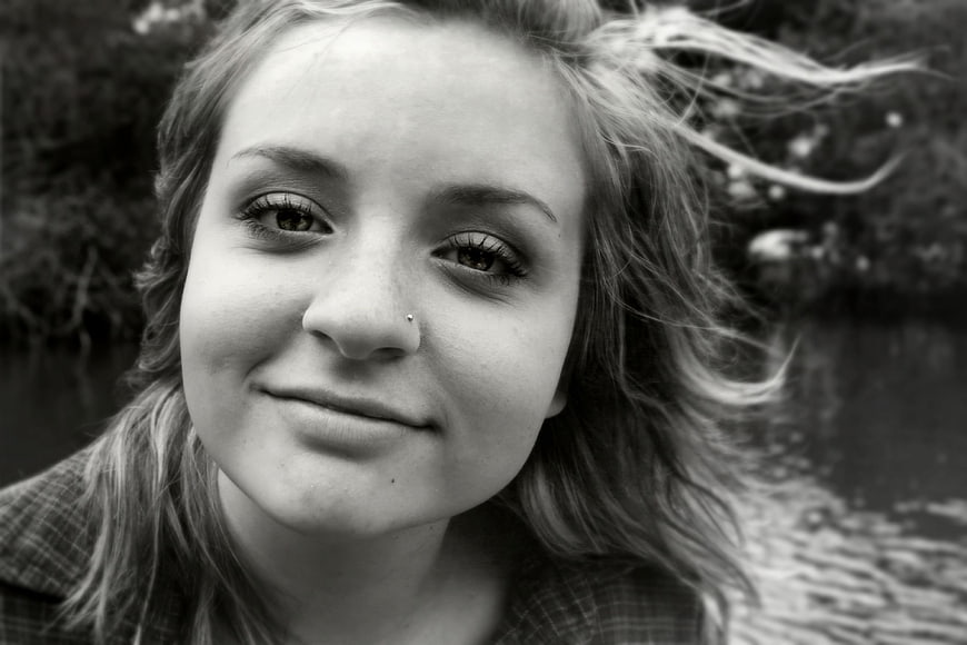 Black and white portrait of smiling young woman outdoors