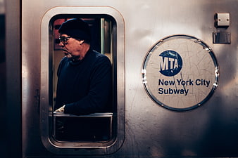 Man in Beanie Looking Out of New York City Subway Train Window