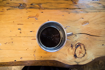 Top View of Black Coffee in Metal Cup on Rustic Wood Table