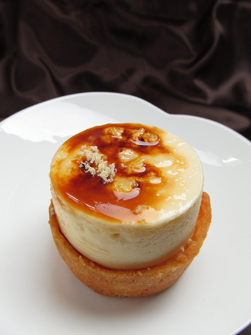 Individual Custard Tart With Caramelized Sugar Topping On White Plate