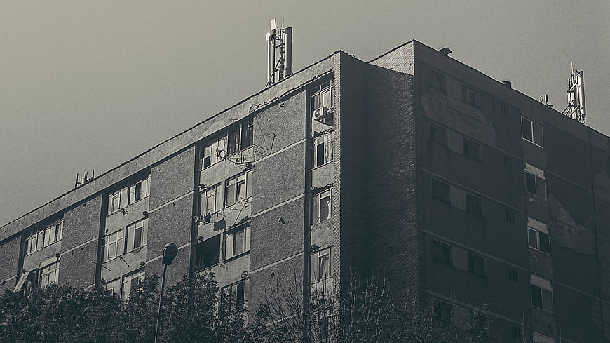 Sepia-toned urban apartment building with rooftop antennas