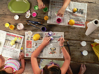 Overhead view of children painting lemons on a wooden table