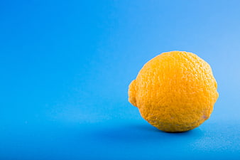 Single Yellow Lemon on Vibrant Blue Background