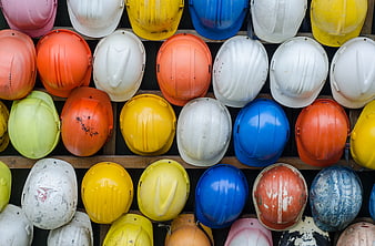 Colorful Construction Safety Helmets on Wooden Shelf
