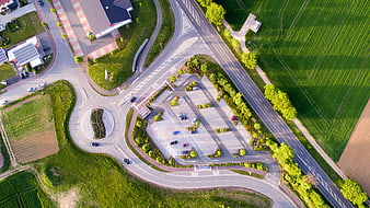 Aerial view of roundabout, parking lot, and green fields