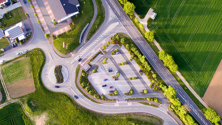 Aerial view of roundabout, parking lot, and green fields