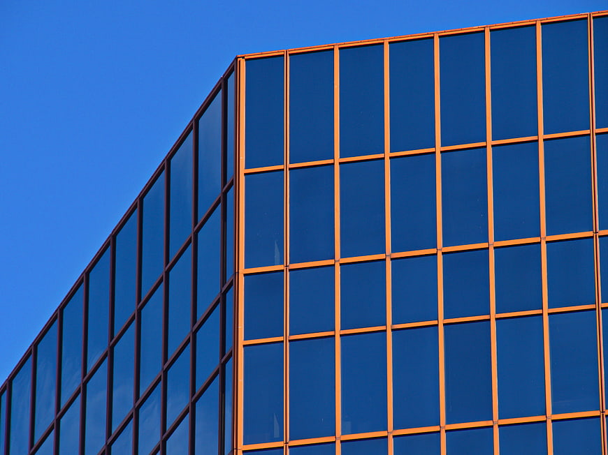 Modern Glass Office Building Facade with Blue Sky