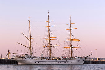 Historic Three-Masted Schooner Docked at Harbor at Sunset