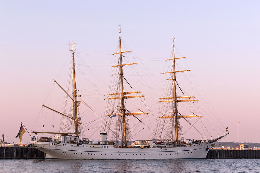 Historic Three-Masted Schooner Docked at Harbor at Sunset