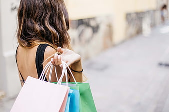 Woman holding colorful shopping bags on city street