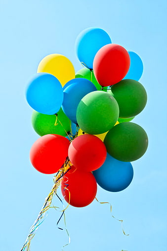 Colorful balloons floating against a clear blue sky
