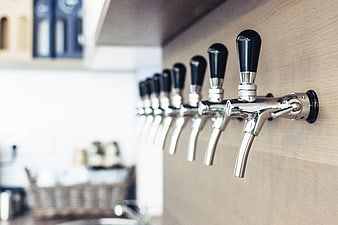 Row of chrome beer taps on wooden bar