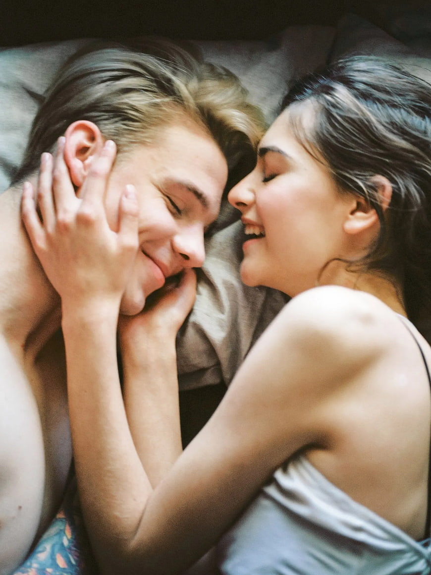 Happy Couple Laughing Together in Bed