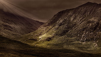 Dramatic Mountain Landscape with Sunbeams and Green Valley