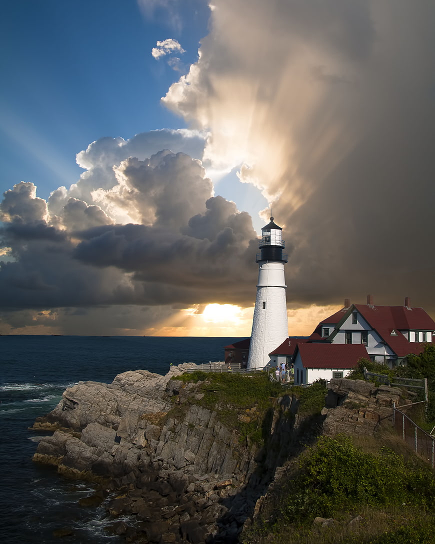 Dramatic Lighthouse on Rocky Cliff with Sunbeams