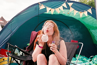 Young woman blowing bubbles in camping tent