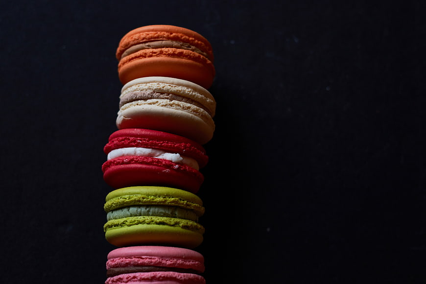 Stack of colorful macarons on dark background