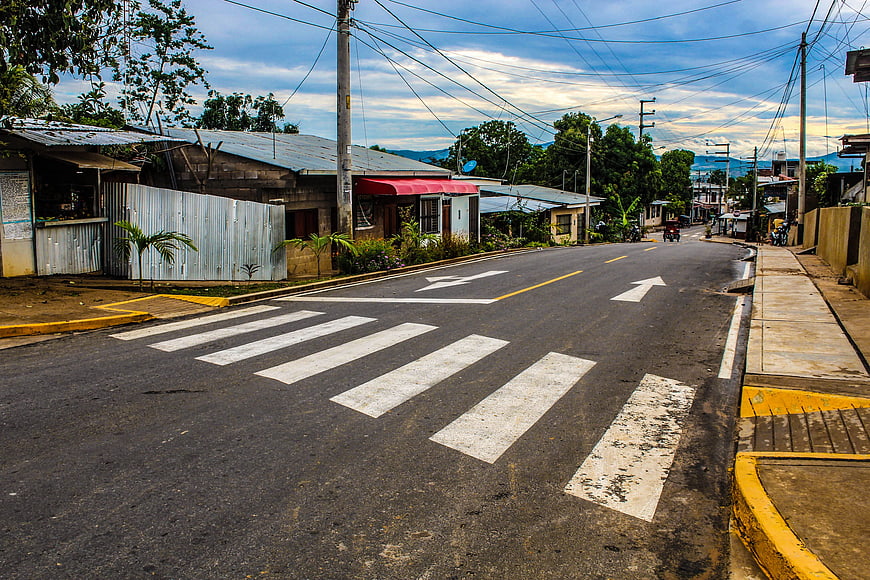 Empty asphalt road with crosswalk in tropical town