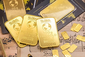 Gold bars and coins on vintage sheet music background