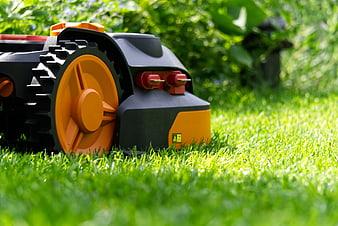Close-up of a robotic lawnmower on a green lawn
