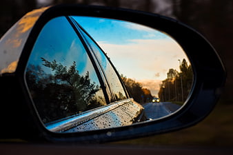 Rainy Road Reflection in Car Side Mirror at Sunset