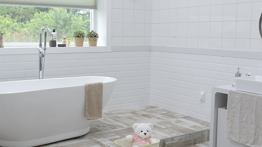 Modern white bathroom with freestanding tub and window