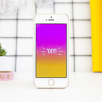 White Smartphone with Colorful Yay Screen on Desk